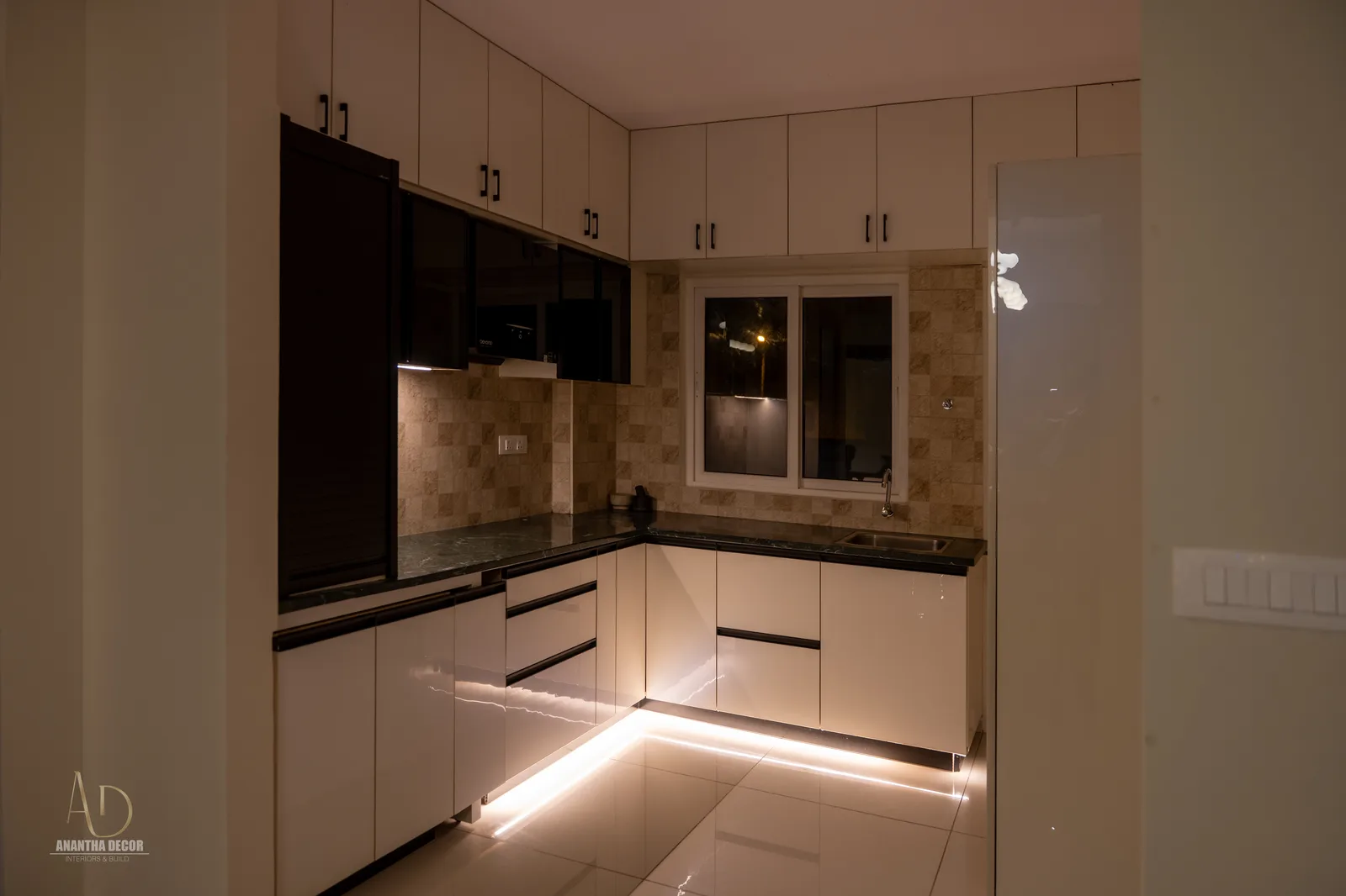 L-shaped modular kitchen with two-tone acrylic cabinetry