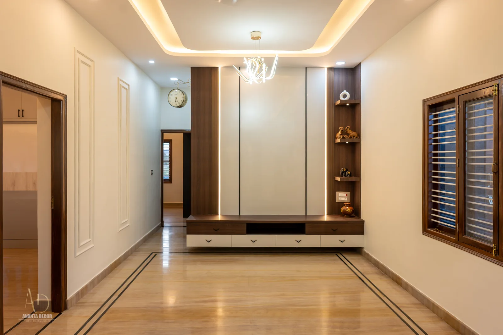 L-shaped modular kitchen layout with glossy cream storage
