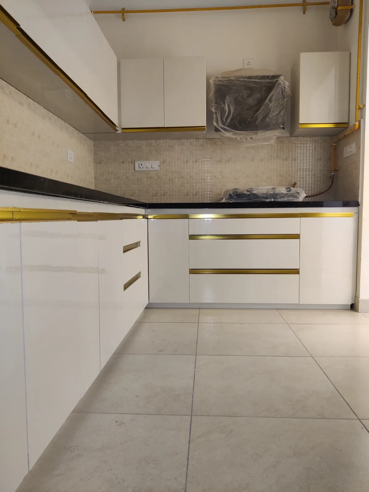 Compact modular kitchen in white gloss with gold handles